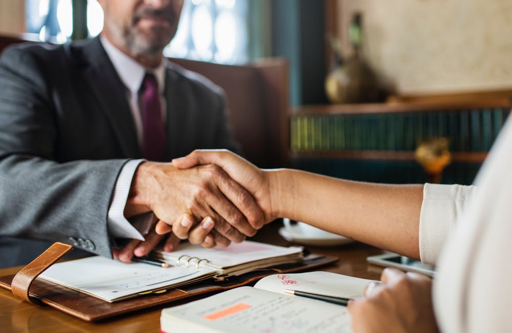 Conveyancer and client shaking hands.